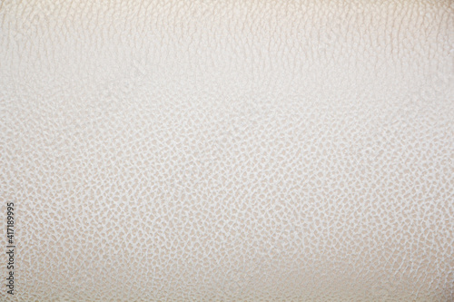 фотографія Piece of silver, beige faux leather texture close-up