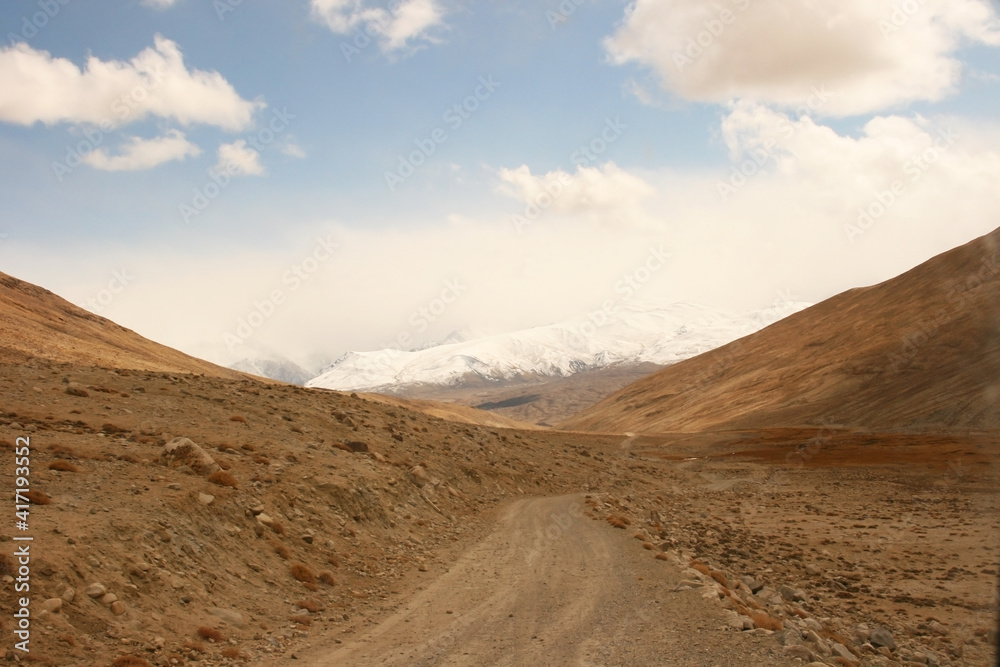 Pamir Highway in the desert landscape of the Pamir Mountains in Tajikistan. Afghanistan is on the left Pamir Highway in the desert landscape of the Pamir Mountains in Tajikistan. Afghanistan is on the left