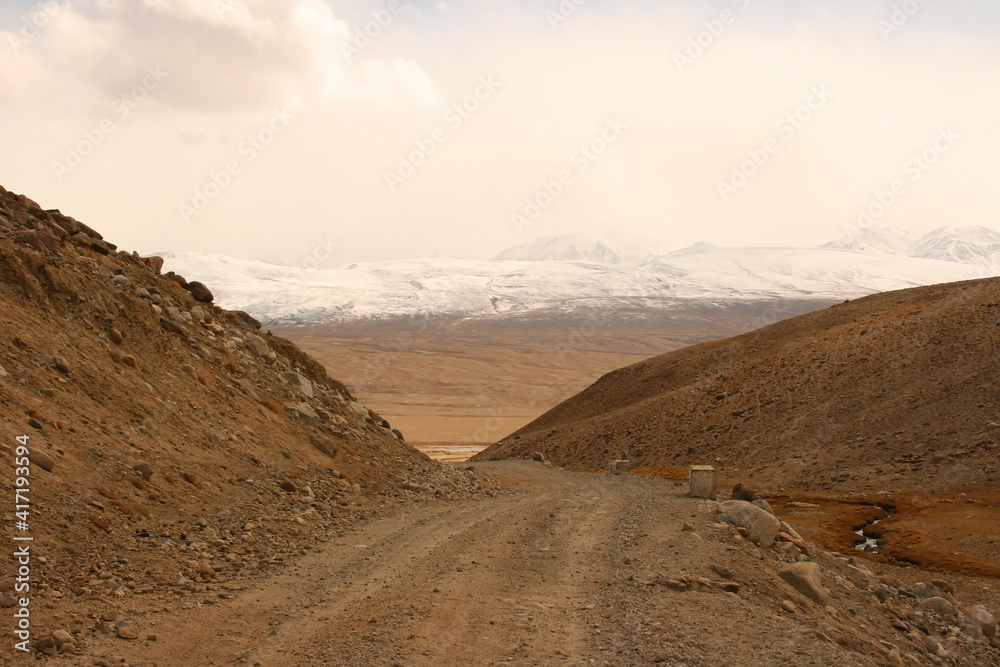 Pamir Highway in the desert landscape of the Pamir Mountains in Tajikistan. Afghanistan is on the left Pamir Highway in the desert landscape of the Pamir Mountains in Tajikistan. Afghanistan is on the left