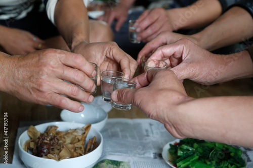Vietnamese party. Close-up of hands toasting rice wine.  Bac Son. Vietnam. 11.08.2017