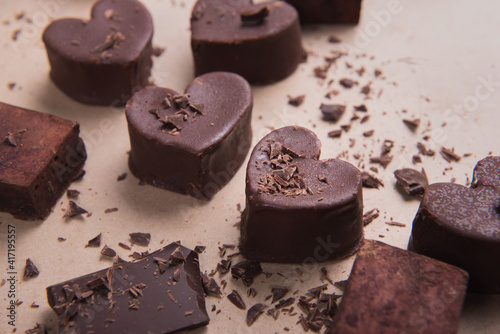Two handmade chocolate hearts on craft background