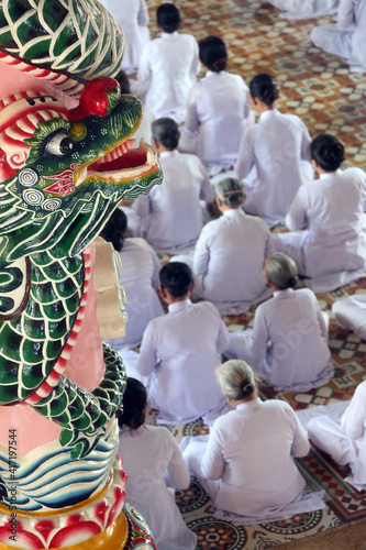 Cao Dai Holy See Temple. Caodaist service under dragon column.  Thay Ninh. Vietnam. photo