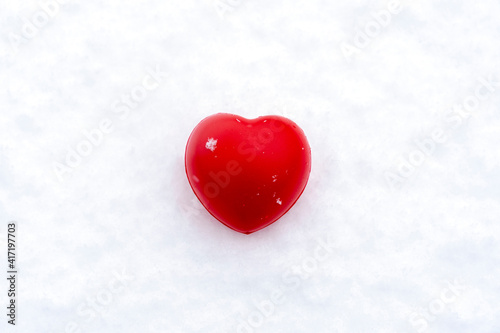 red heart in the snow, the concept of love and family relations, the background for a postcard, a place for your text