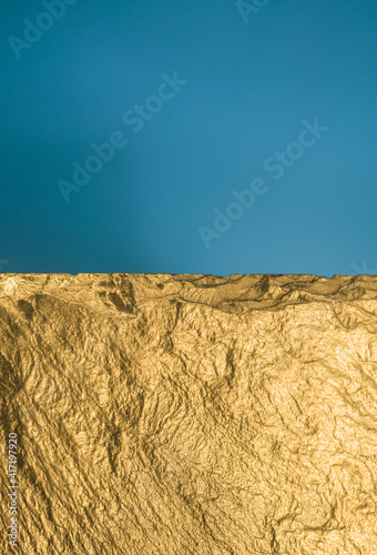 Gold texture. Rough structure mineral. Rock texture. Gold Ore. Gold rocks. Stone blue background.