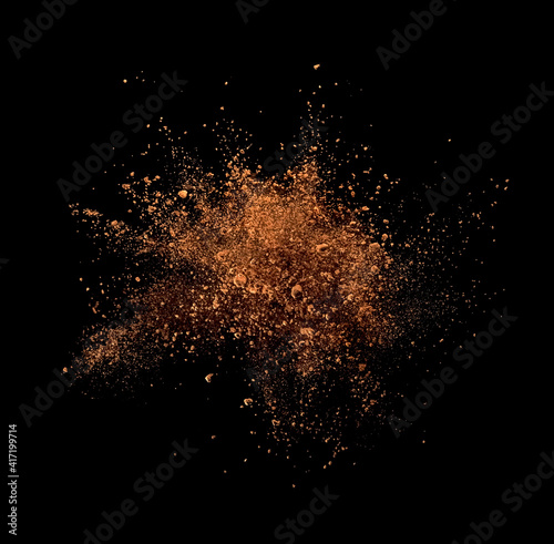 Cocoa powder explosion on black background