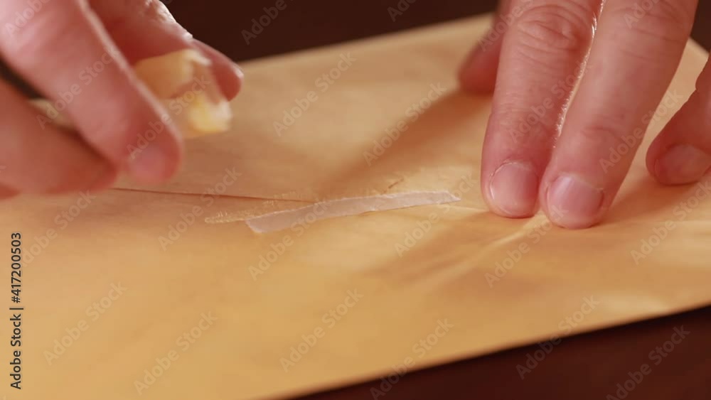 Male hands opening a yellow envelope. This clip can be used to describe a postal shipping concept Male hands opening a yellow envelope. This clip can be used to describe a postal shipping concept