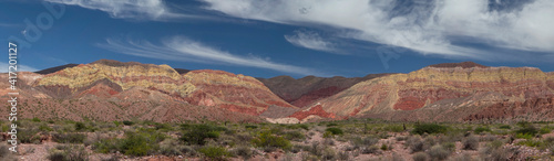 Desert background. Panorama view of the arid desert and colorful mountains under a blue sky. 