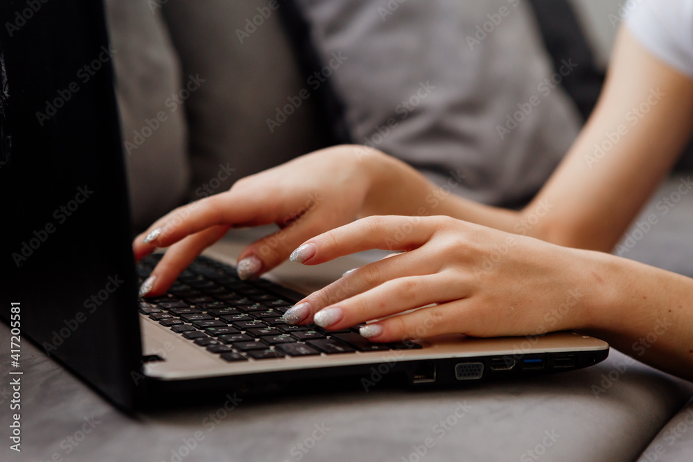 close-up of a girl's hands typing on a laptop keyboard close-up of a girl's hands typing on a laptop keyboard