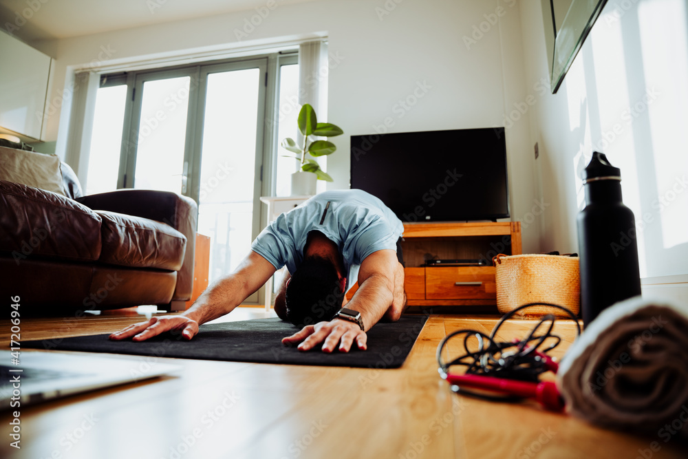 Mixed race business man stretching before work day performing child's pose Mixed race business man stretching before work day performing child's pose