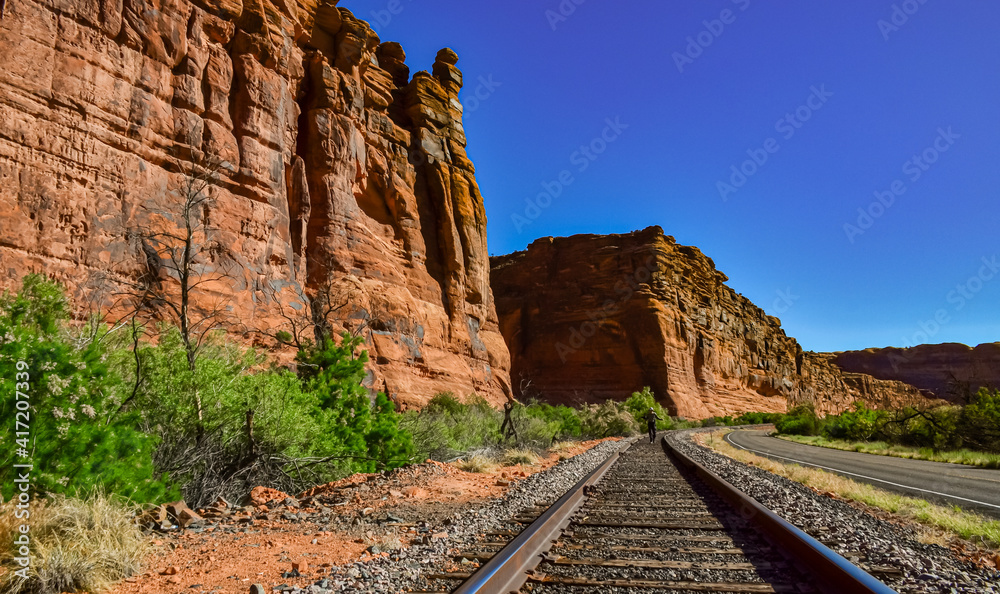 Railroad at the bottom of a canyon next to Layered Geological Formations of Red Rocks. Railroad at the bottom of a canyon next to Layered Geological Formations of Red Rocks.