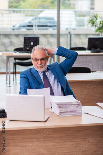 Old male boss employee working in the office