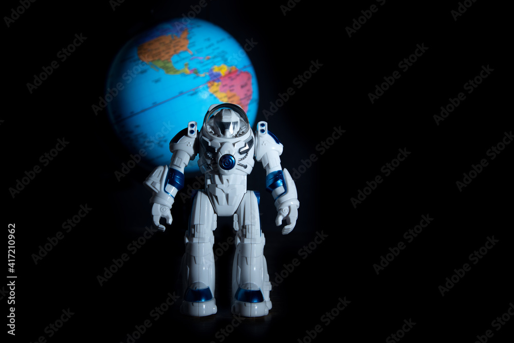 Toy astronaut on the background of the planet earth of the continents of America on a dark background like in space. Toy astronaut on the background of the planet earth of the continents of America on a dark background like in space.