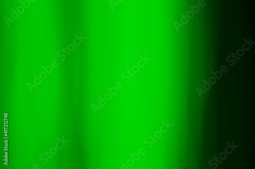 Green abstract background - lines and streaks of light. Blurred, irregular light elements on black background. Green fanciful 3d patterns.