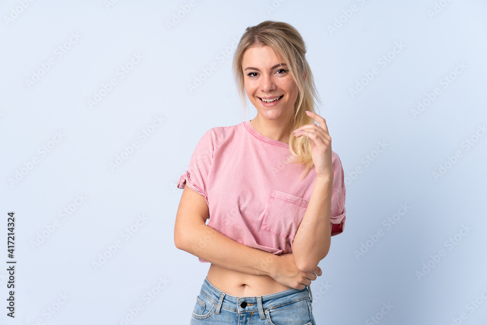 Blonde woman over isolated blue background laughing Blonde woman over isolated blue background laughing