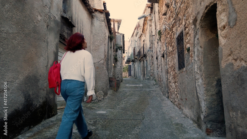 Giovane ragazza con jeans cammina per la città abbandonata
