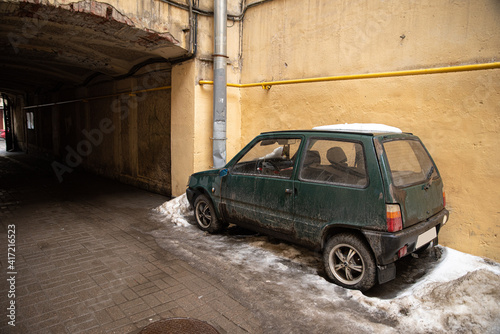 Car on a snowdrift, in the yard, near a painted wall