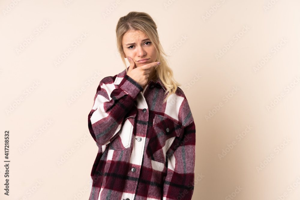 Blonde woman over isolated background having doubts