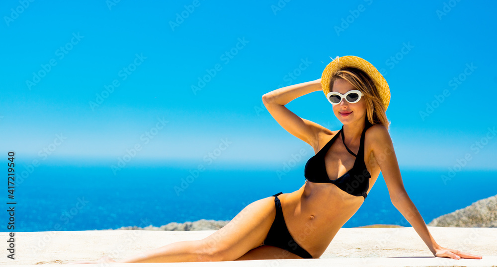 girl in bikini with blue sea and sky on background