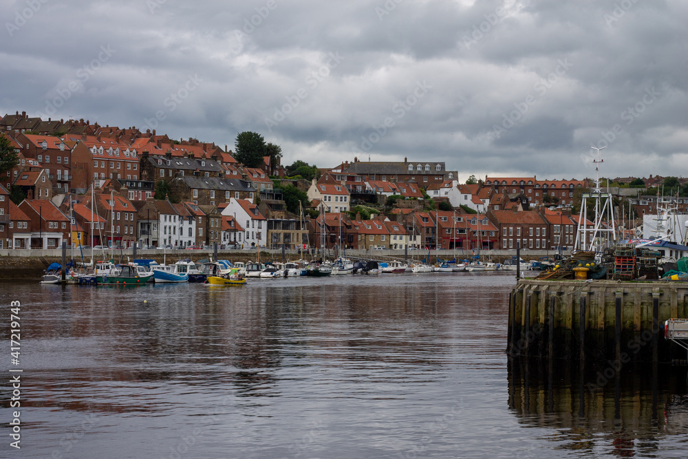 The historic harbour at Whitby North Yorkshire showing small boats and the town in the distance
