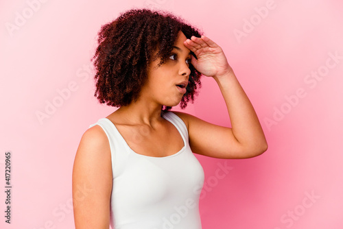 Young african american mixed race woman isolated looking far away keeping hand on forehead.