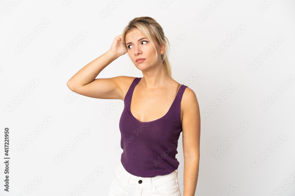 Young Russian woman isolated on white background having doubts while scratching head Young Russian woman isolated on white background having doubts while scratching head