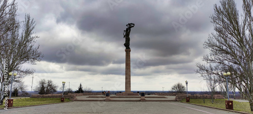 View of the park and in the city of Kherson. Glory park. Ladder to the stele. Monument to the soldier. Trees without leaves and cloudy weather. Ukraine. Europe