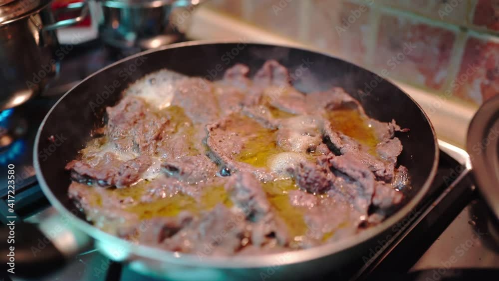 Veal fillets frying with olive oil and garlic in cooking pan, sizzling meat slices for pizzaiola preparation. Traditional italian food recipe Veal fillets frying with olive oil and garlic in cooking pan, sizzling meat slices for pizzaiola preparation. Traditional italian food recipe