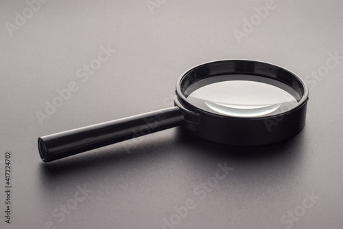 Magnifying glass with plastic handle on a dark background, selective focus