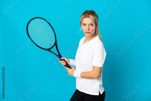 Young Russian woman isolated on blue background playing tennis © luismolinero