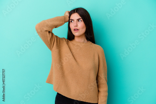 Young caucasian woman isolated on blue background being shocked, she has remembered important meeting.