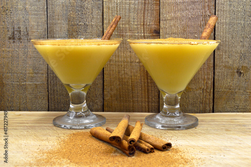 Boza and cinnamon sticks, traditional Turkish cuisine drinks, on wooden background photo