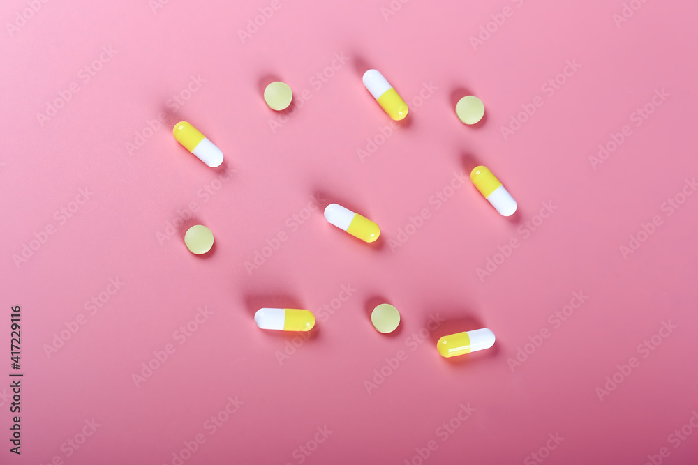 yellow pills pills on a pink background