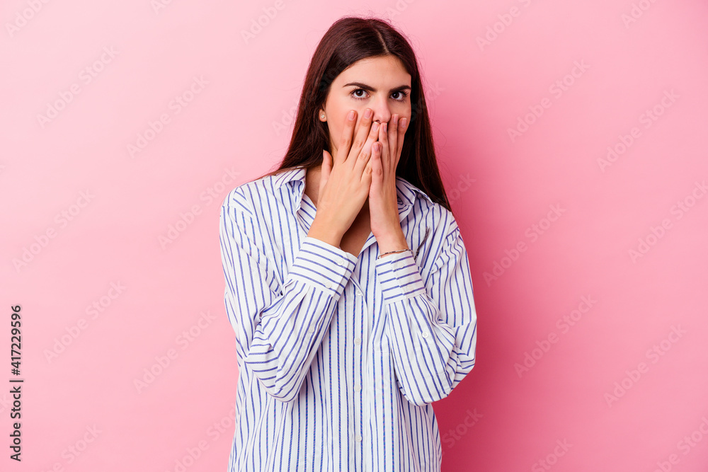 Young caucasian woman isolated on pink background shocked, covering mouth with hands, anxious to discover something new. Young caucasian woman isolated on pink background shocked, covering mouth with hands, anxious to discover something new.