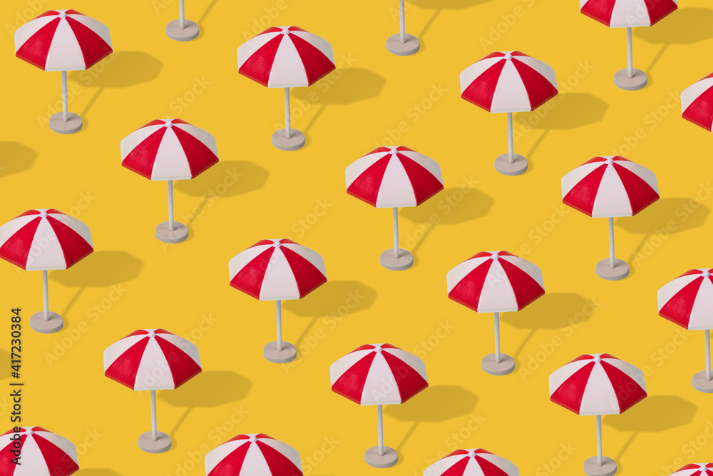Trendy summer pattern of colorful umbrellas on a illuminating yellow background.