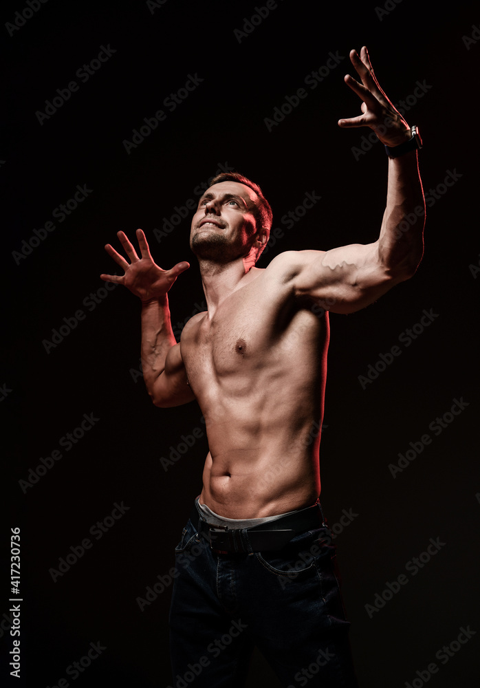 the very muscular handsome sexy guy on black background, naked torso.