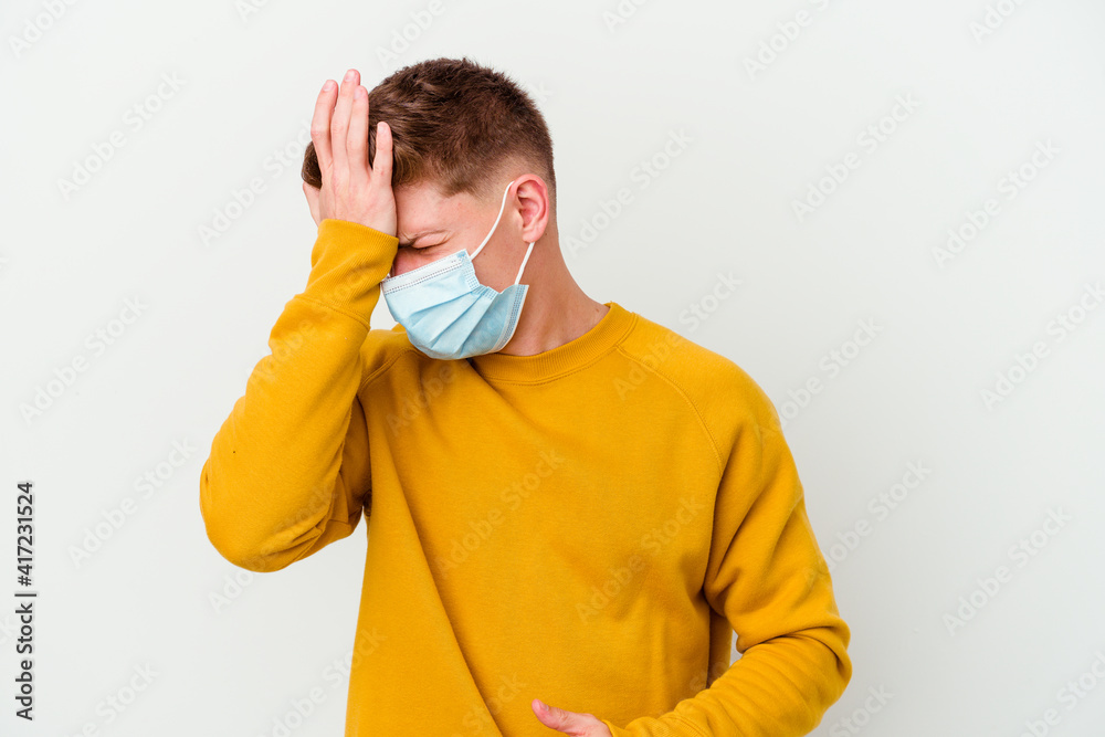 Young man wearing a mask for coronavirus isolated on white background forgetting something, slapping forehead with palm and closing eyes. Young man wearing a mask for coronavirus isolated on white background forgetting something, slapping forehead with palm and closing eyes.