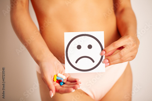 Woman Health, Female Body Holding Sad Smile Card Near Stomach. © Maksymiv Iurii