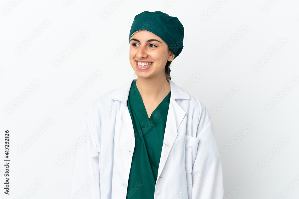 Surgeon caucasian woman isolated on white background looking to the side and smiling Surgeon caucasian woman isolated on white background looking to the side and smiling