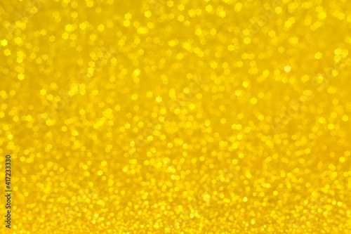 Golden lights in the shape of stars for a festive background. Abstract, bright yellow background, blurred bokeh.