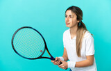 Young caucasian woman isolated on blue background playing tennis