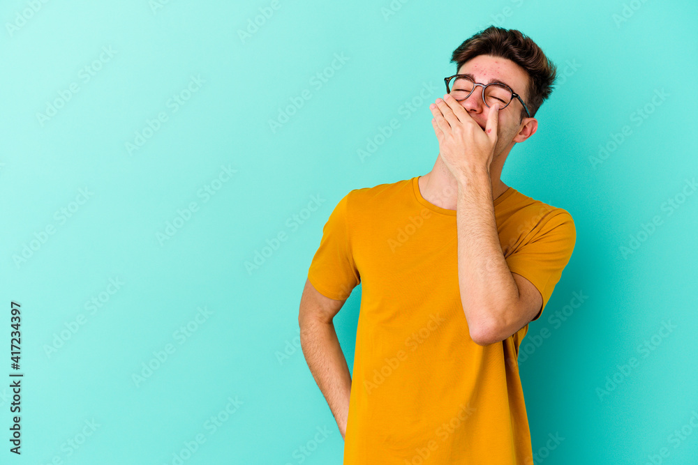Young caucasian man isolated on blue background laughing happy, carefree, natural emotion. Young caucasian man isolated on blue background laughing happy, carefree, natural emotion.
