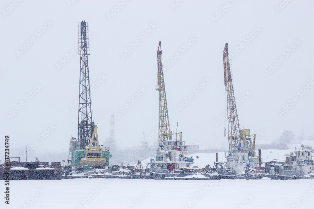 cranes in the port during a snowfall cranes in the port during a snowfall