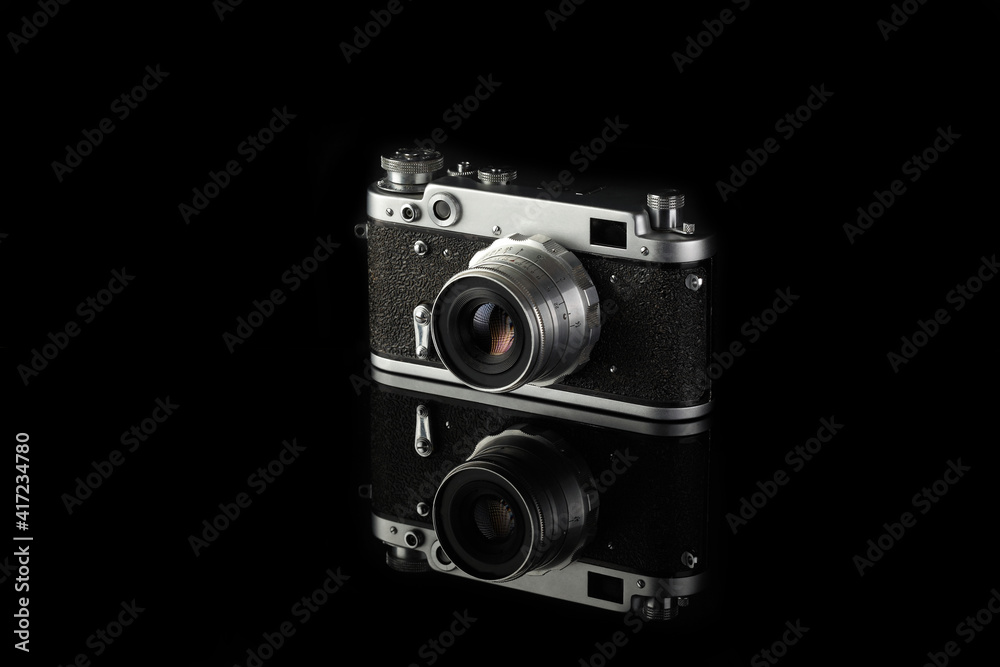 The rare old rangefinder film camera on black glass background.