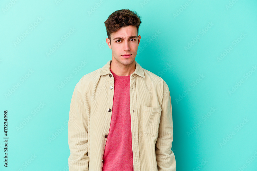 Young caucasian man isolated on blue background sad, serious face, feeling miserable and displeased. Young caucasian man isolated on blue background sad, serious face, feeling miserable and displeased.