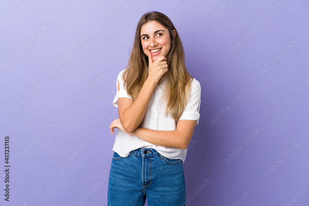 Young woman over isolated purple background looking to the side and smiling Young woman over isolated purple background looking to the side and smiling