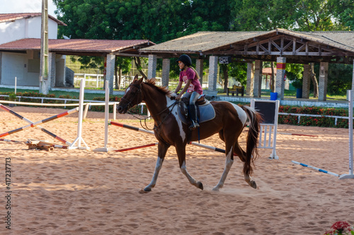 Jovem menina cavalgando