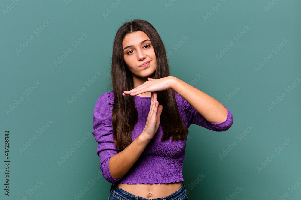 Young Indian woman isolated on blue background showing a timeout gesture. Young Indian woman isolated on blue background showing a timeout gesture.