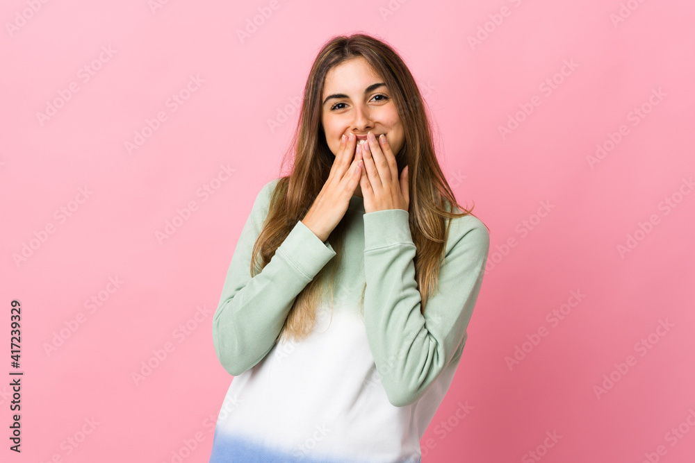 Young woman over isolated pink background happy and smiling covering mouth with hands Young woman over isolated pink background happy and smiling covering mouth with hands