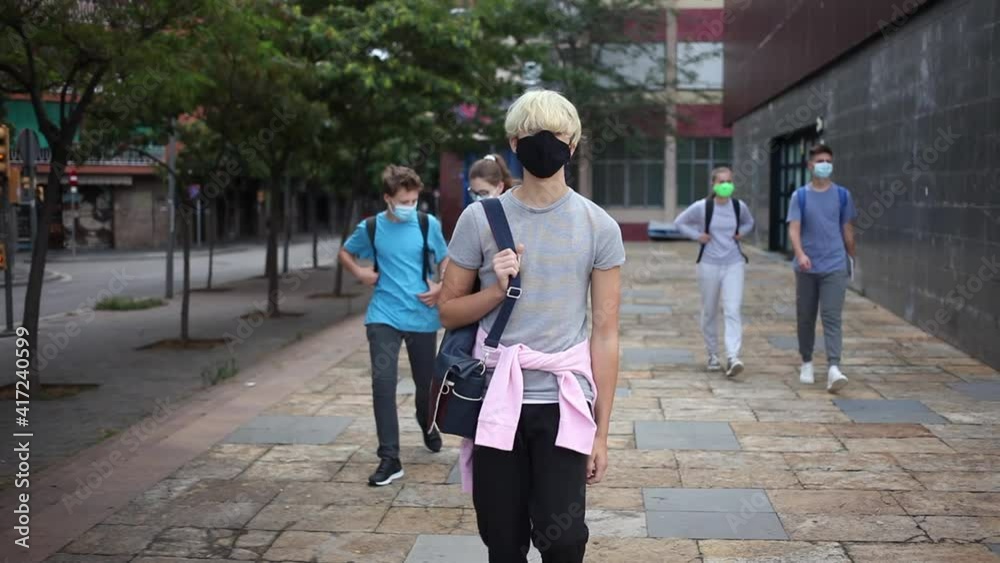 Portrait of teenager in protective mask with backpack going to school lessons on sunny autumn day. New lifestyle during coronavirus pandemi