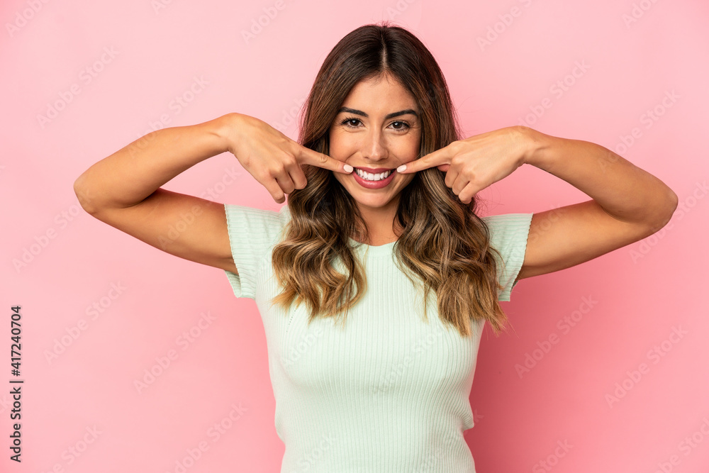 Young caucasian woman isolated smiles, pointing fingers at mouth. Young caucasian woman isolated smiles, pointing fingers at mouth.